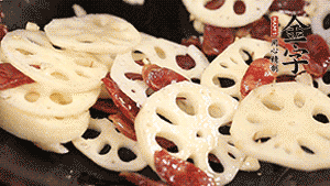 依次下香腸片、藕片翻炒均勻，加適量清水燜熟。