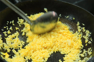 大火加熱炒鍋，再入油，燒到四至五成熱時(shí)倒入雞蛋液，在未凝結(jié)之前，加米飯煸炒，不停翻炒并用鍋鏟將成塊的米飯碾開、撥散。