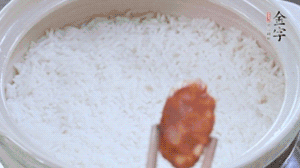 煮開后轉(zhuǎn)小火，當米飯出現(xiàn)小孔時，鋪上金字麻辣香腸。