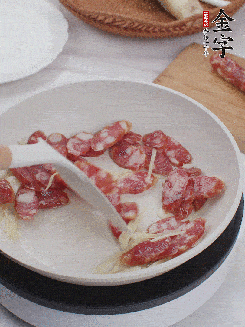 油溫3成熱時，下姜絲、蒜片、香腸炒出油脂。