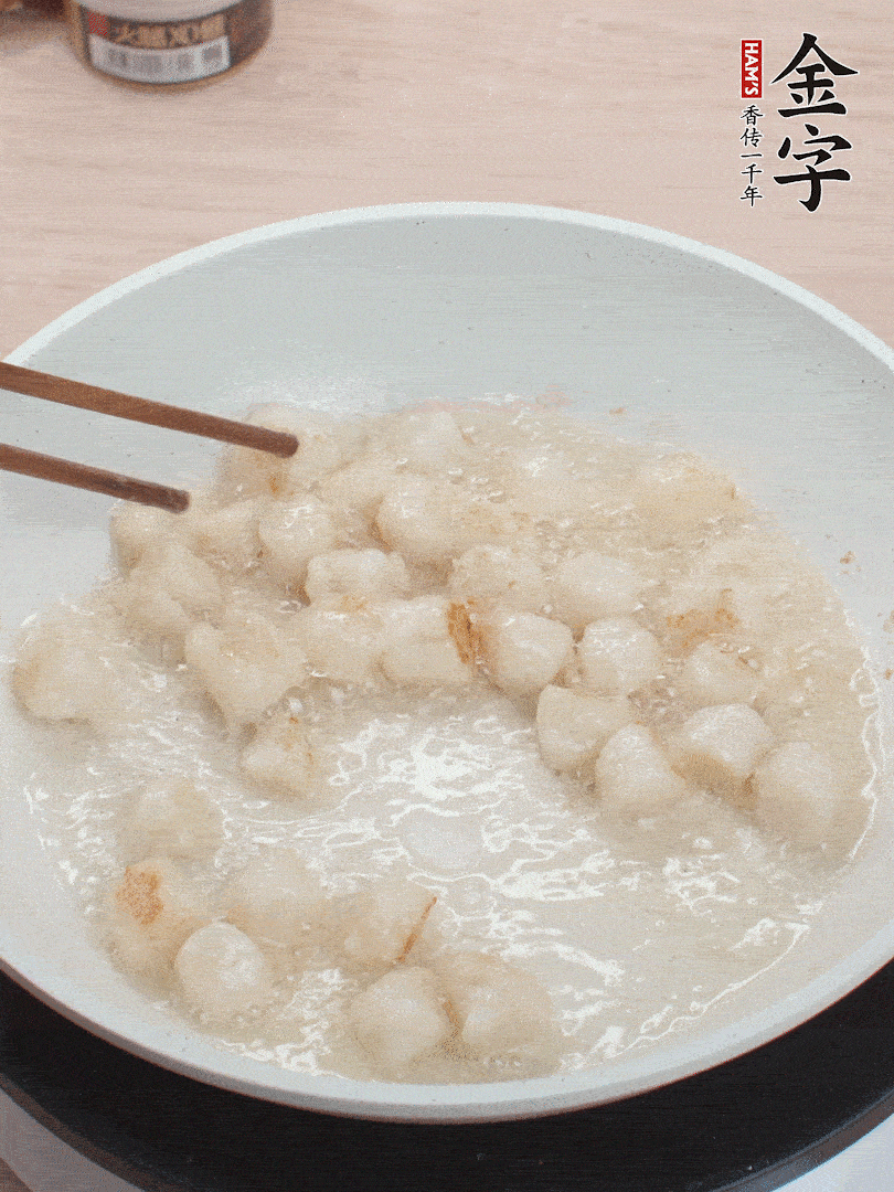 油溫4成熱，鮮貝蘸干淀粉下鍋煎，一面微黃后翻面。