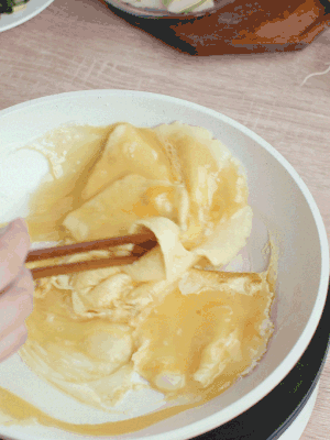 油6成熱時(shí)，下雞蛋液，邊緣凝固時(shí)翻拌成塊狀。