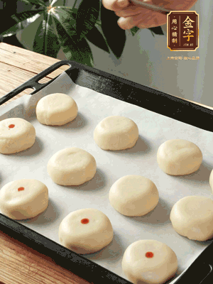 收口向下放在案板上，輕輕將月餅坯按扁，用筷子點(diǎn)紅點(diǎn)做裝飾