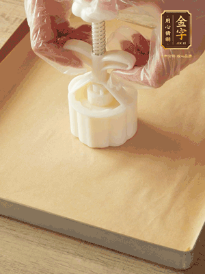 取一個(gè)面團(tuán)，捏扁，中間厚，四周薄。虎口往上推，直到收口，把餅胚放入模具里，壓2-3下